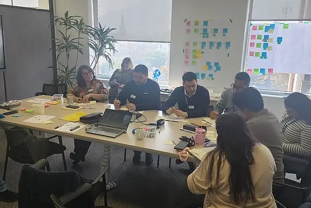 Un equipo trabajando en una mesa con notas adhesivas y plumones